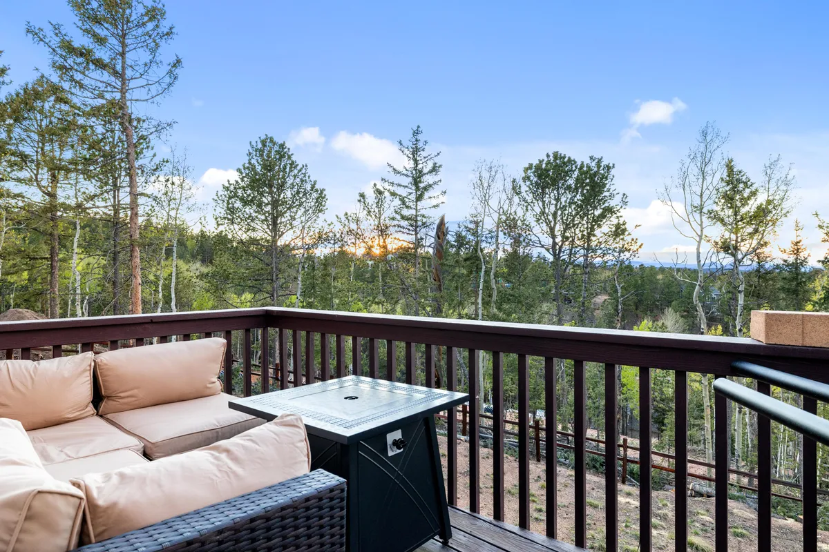 An inviting outdoor seating area is set against the backdrop of natural scenery and distant mountains. The space provides a peaceful spot for relaxing, entertaining, or simply soaking up the surroundings. The view suggests the end-of-day gatherings mentioned in the section, such as group meals on the deck or unwinding together as the sun sets.